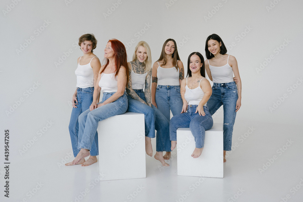 Cheerful diverse smiling women in similar clothes Cheerful diverse smiling women in similar clothes