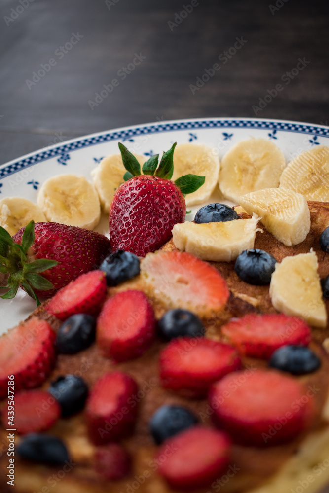 Closeup shot of delicious waffles with strawberry, banana and blueberries