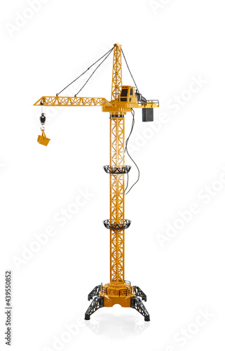 Toy construction crane made of bright plastic, with a remote control, isolated on a white background with a shadow.