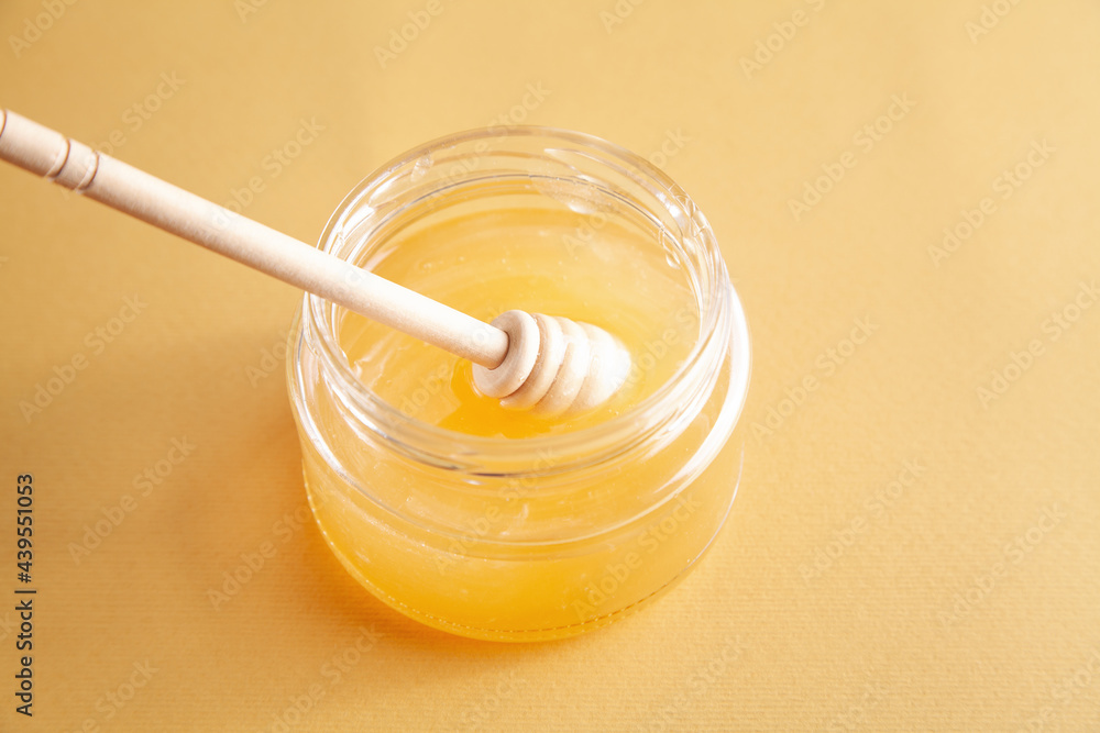 Honey jar with dipper on yellow background. Honey jar with dipper on yellow background.