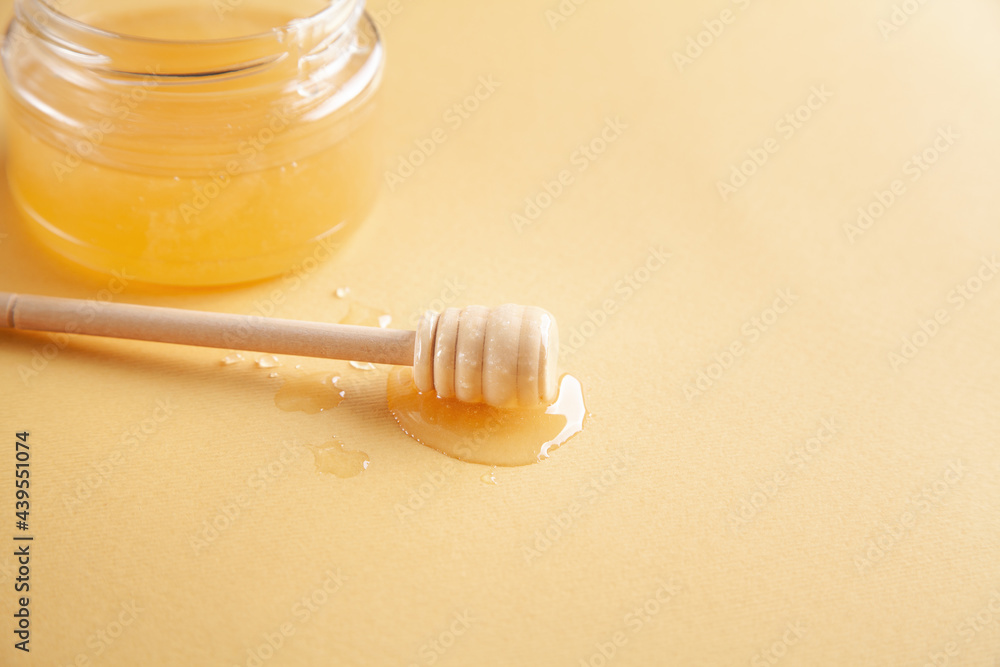 Honey jar with dipper on yellow background. Honey jar with dipper on yellow background.