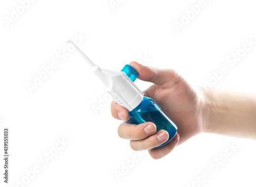 The hand holds the dental irrigator. Close up. Isolated on a white background