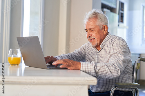 Senior am Laptop Computer zu Hause schreibt eine Email