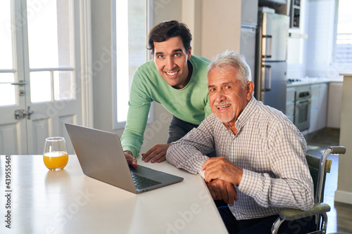 Junger Mann und Senior haben Spaß am Laptop Computer photo