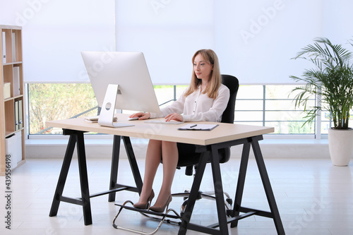 Obraz na płótnie Woman using footrest while working on computer in office