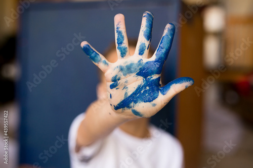 Child's hand covered in blue paint
 photo