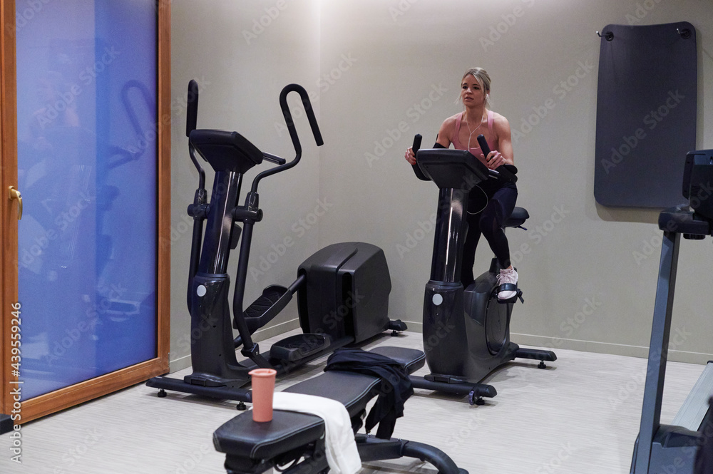 Woman using a gym stationary bike Woman using a gym stationary bike