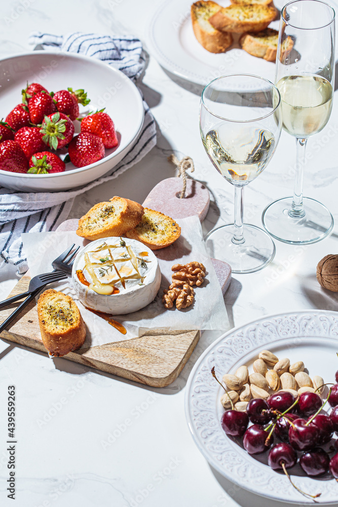 Baked Camembert or Brie with thyme and maple syrup. Cheese, fruits, bread and nut to white wine.