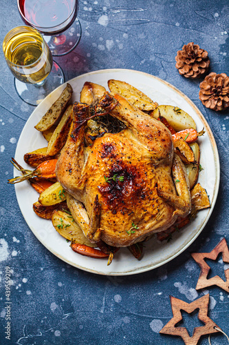 Christmas baked whole chicken stuffed with thyme, lemon and vegetables. Christmas food, holiday dish, decorated background.