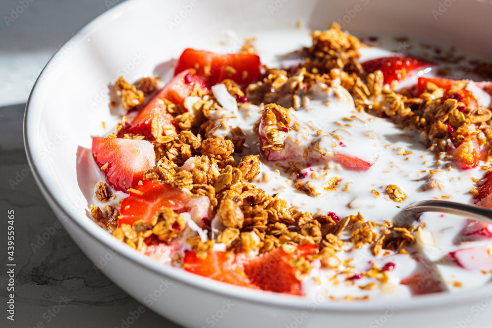 Granola with yogurt and strawberries in white bowl, close-up. Healthy breakfast concept. Granola with yogurt and strawberries in white bowl, close-up. Healthy breakfast concept.