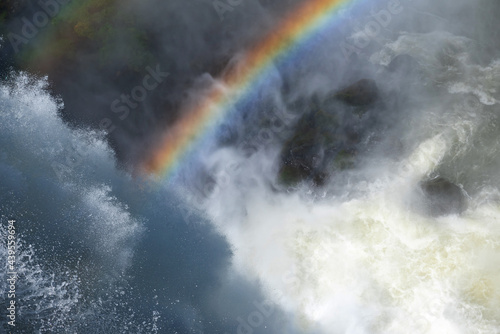 Colorful rainbow over waterfall stream