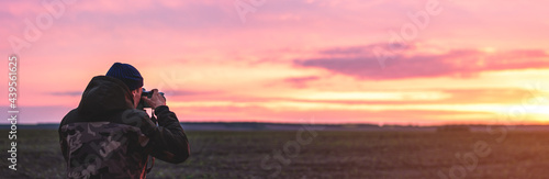 The photographer on the sunset shooting sunset landscape. Travel nature photography.