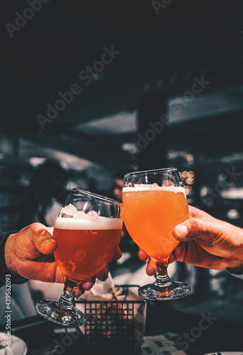 Closeup view of a two glass of beer in hand Fototapeta