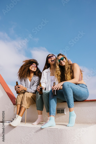 Company of cheerful women laughing on terrace photo