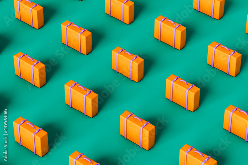 pattern of multiple orange suitcases on green background photo