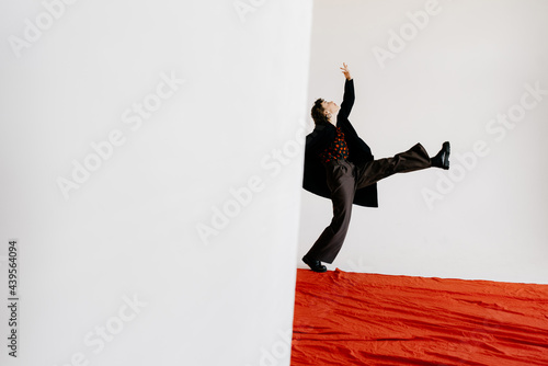 Stylish expressive woman on red carpet in studio