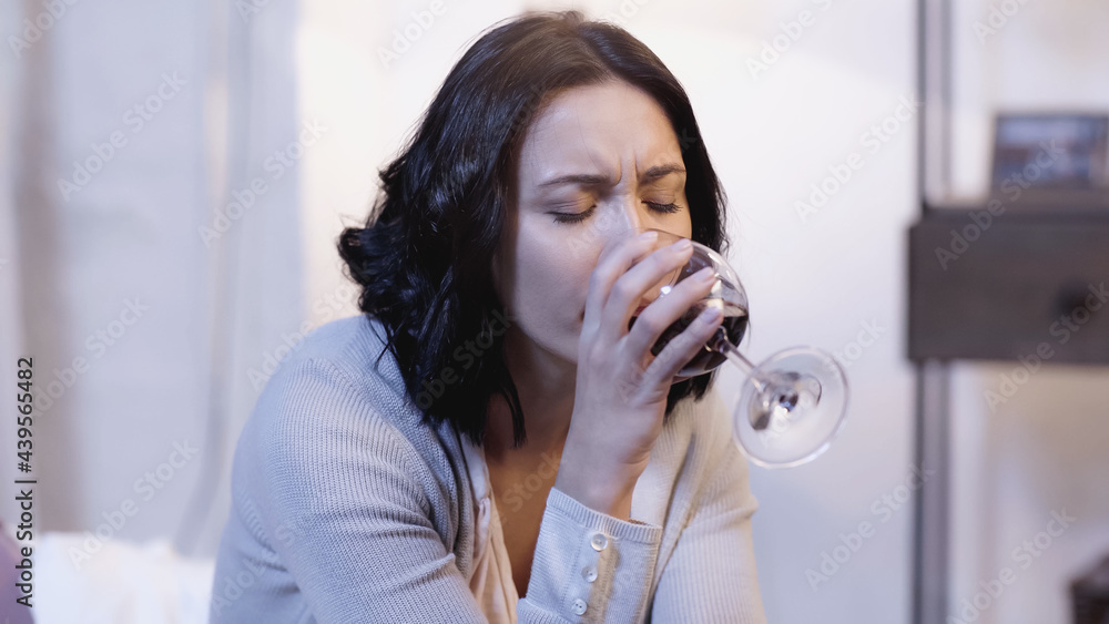 lonely woman drinking red wine from glass with closed eyes at home lonely woman drinking red wine from glass with closed eyes at home