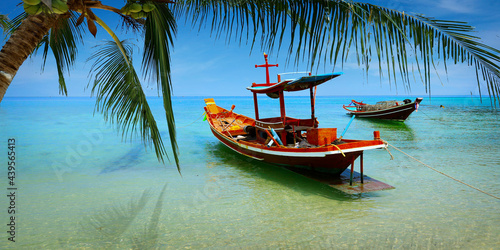 long tail boat, in white sand beach in the andaman sea