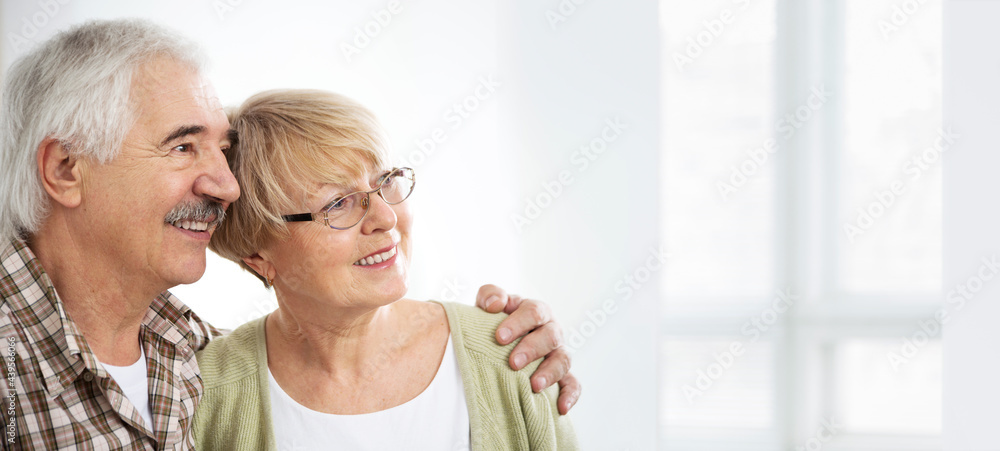 Elderly couple hugging at home and smiling Elderly couple hugging at home and smiling