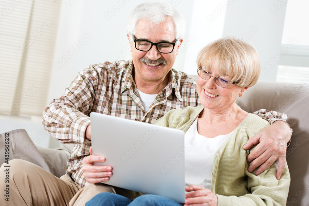 Elderly couple talking using laptop together Elderly couple talking using laptop together