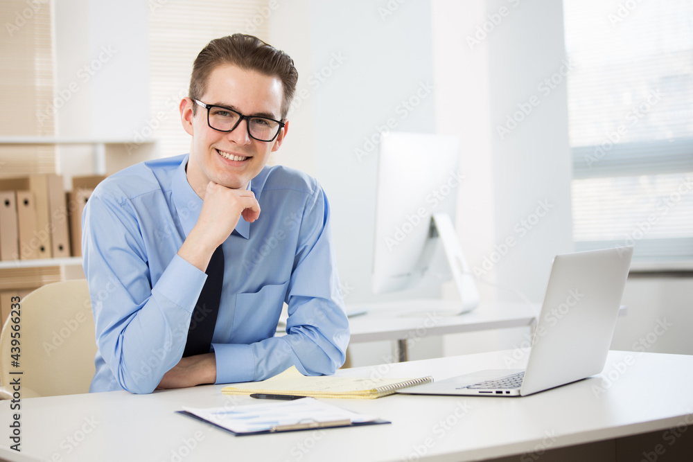 Portrait of young businessman working with laptop at office Portrait of young businessman working with laptop at office