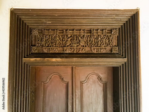 An ornately carved wooden door to an old heritage house in a village in Chettinad. photo