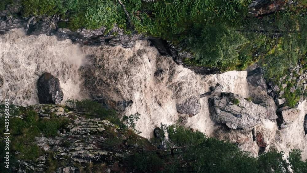 Fast flowing raging river. Soil and mud is moving towards down. After strong rain or Melting ice Giant roiling brown muddy water in the mountains. North Caucasus Ossetia Fast flowing raging river. Soil and mud is moving towards down. After strong rain or Melting ice Giant roiling brown muddy water in the mountains. North Caucasus Ossetia