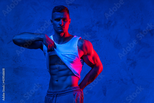 Obraz na plátně Handsome bodybuilder showing his abdominal muscles