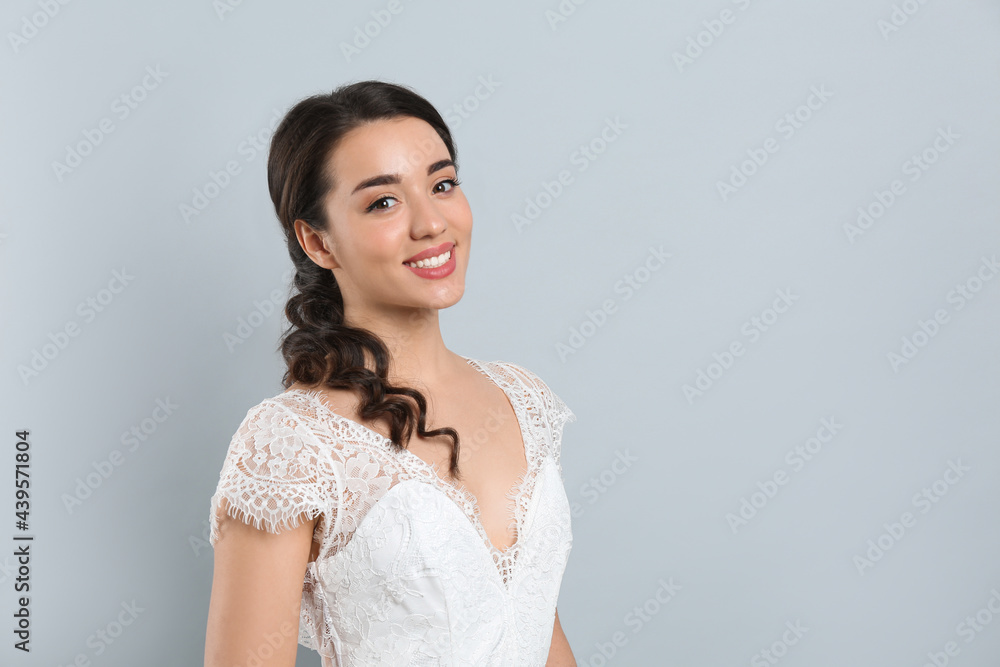 Young bride with beautiful wedding hairstyle on light grey background. Space for text Young bride with beautiful wedding hairstyle on light grey background. Space for text