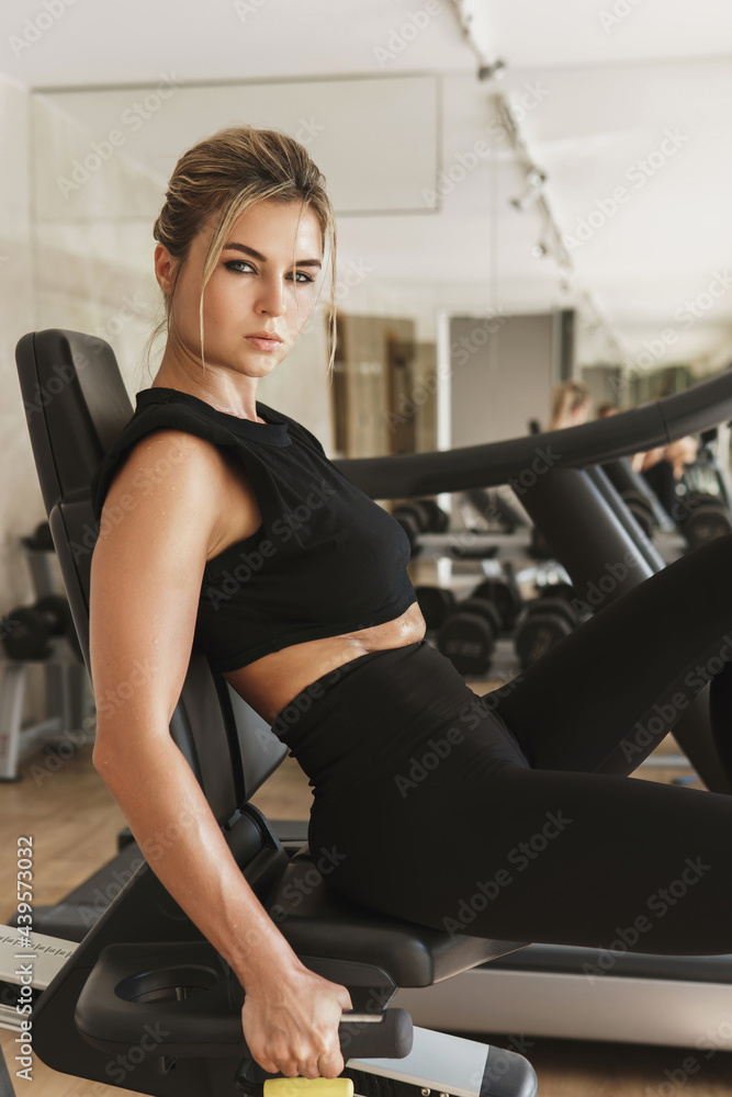 Athletic woman exercising on a stationary bike in the gym Athletic woman exercising on a stationary bike in the gym