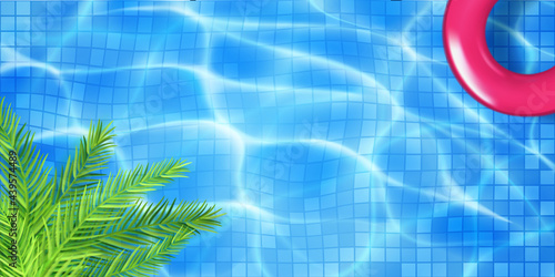 Swimming pool top view with mosaic tiles, inflatable ring and palm leaves. Water surface in light blue colors with sunlight glares and caustic ripples. Summer holiday background.