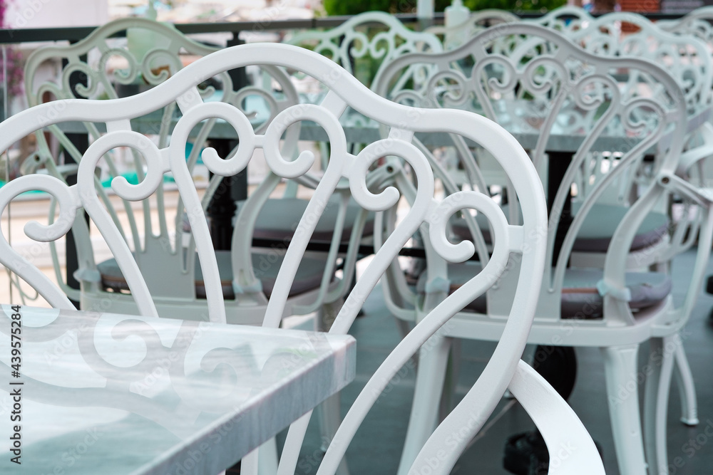 Summer open air mediterranean cafe, white and black chair on terrase or balcony, lazy afternoon Summer open air mediterranean cafe, white and black chair on terrase or balcony, lazy afternoon