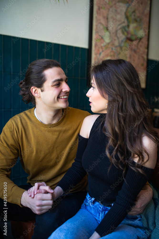 Fototapeta premium Happy young couple bonding at cafe sitting at the bar