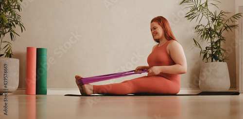 Fotografie Plus size woman workout with resistance band