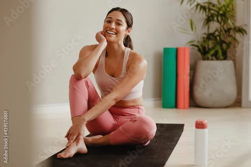 Fototapeta na wymiar Woman taking a break from yoga session at gym