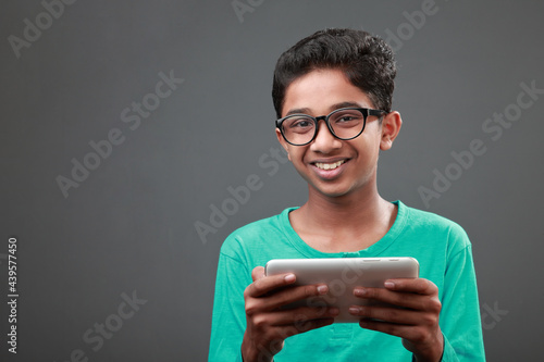 Young boy with smiling face holding a digital tablet photo