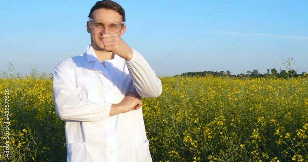 A plant specialist, checking the field soy, in a white coat makes a test analysis in a tablet, a background of greenery. Concept ecology, bio product, inspection, water, natural products, professional