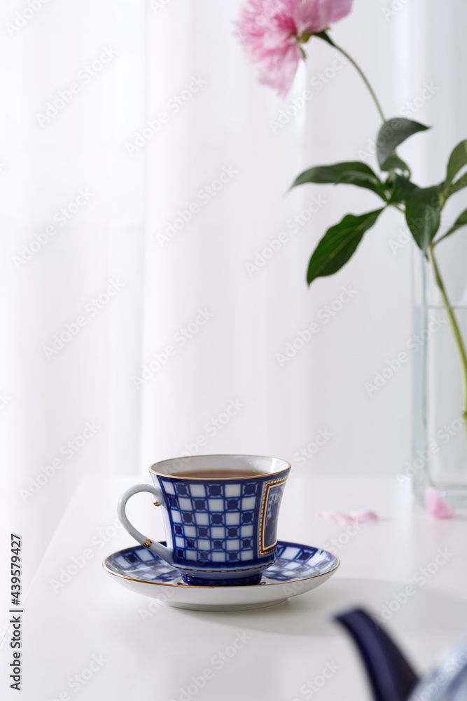 Fresh tea in a beautiful ceramic cup on a white table. Fresh tea in a beautiful ceramic cup on a white table.