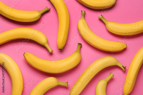 Ripe yellow bananas on pink background, flat lay