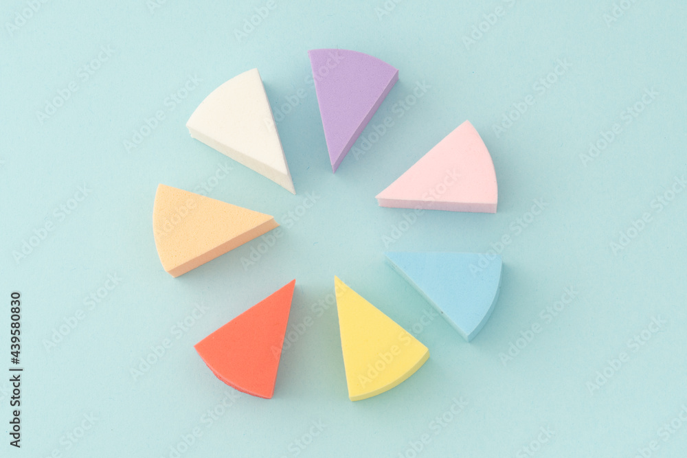 Colourful makeup sponges triangular shape on a gentle blue background Colourful makeup sponges triangular shape on a gentle blue background