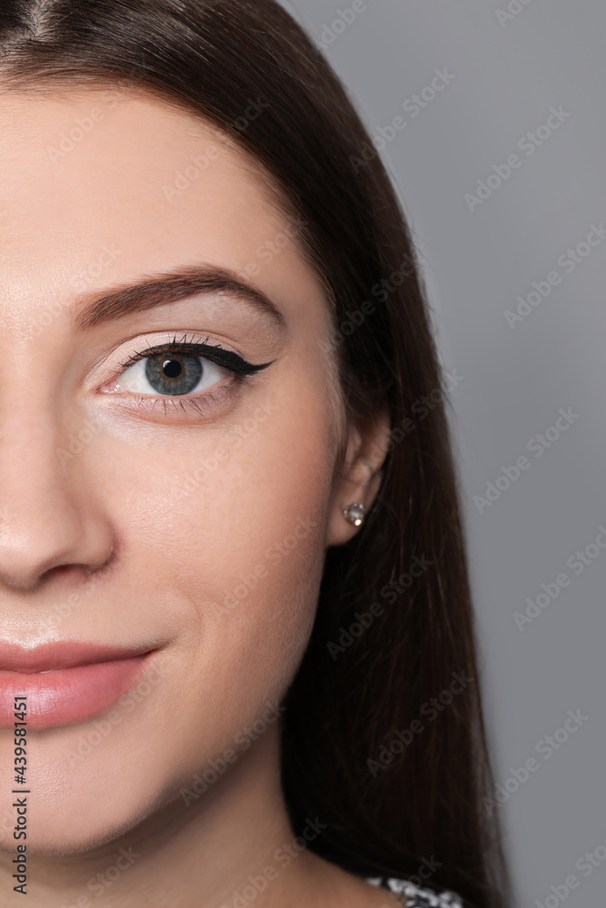 Fototapeta premium Beautiful woman with black eyeliner on grey background, closeup
