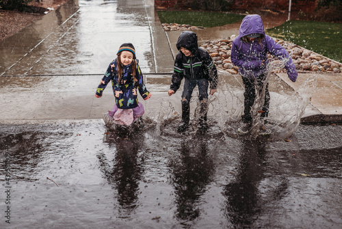 Siblings splashing in rain