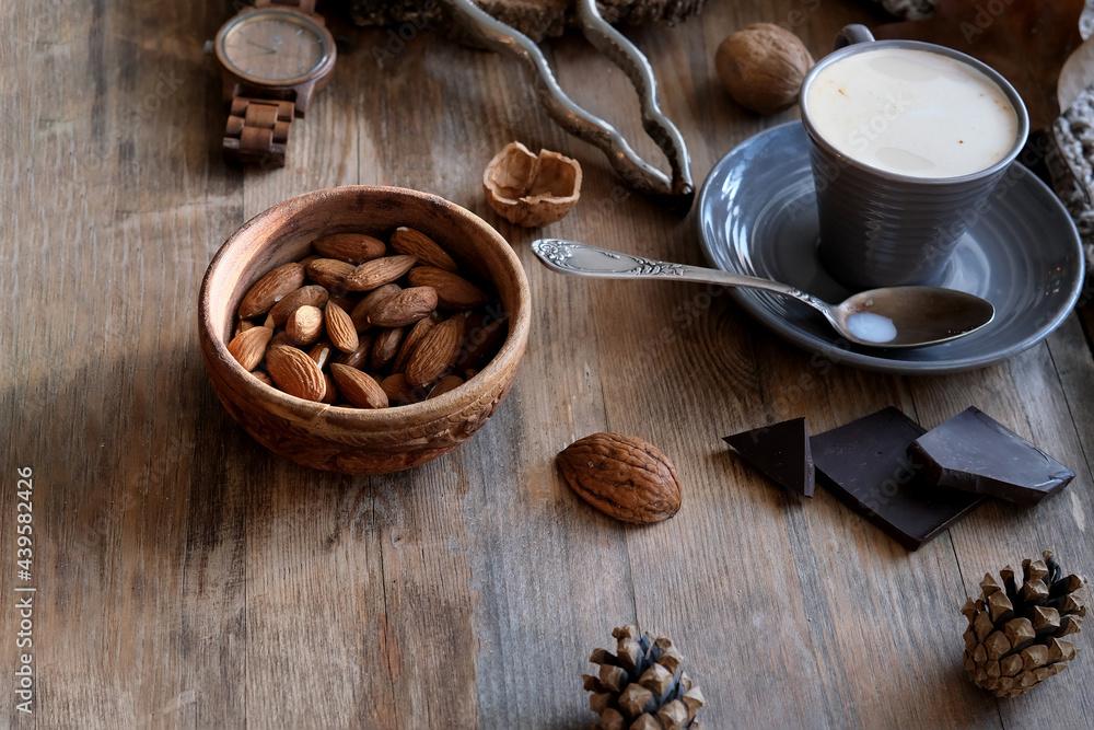 cup of coffee, different kinds of nuts, walnut, hazelnuts, almonds on old wooden table boards, edible seed kernels, food concept, confectionery ingredient cup of coffee, different kinds of nuts, walnut, hazelnuts, almonds on old wooden table boards, edible seed kernels, food concept, confectionery ingredient