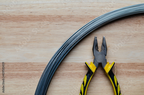 Hand tools, pliers, made from metal materials, so it has good properties for use in cutting wire is placed on the softwood background.
