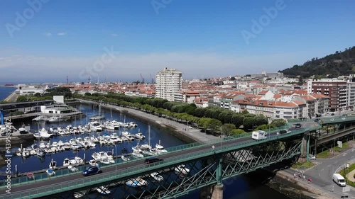 Viana do Castelo, Portugal - June 10, 2021: DRONE AERIAL FOOTAGE - Gustave Eiffel Bridge over the river Lima in Viana do Castelo. Aerial panoramic cityscape view of Viana and the Marina.