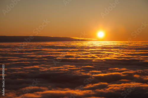 Sunset above the clouds captured from a motorized paraglider © Ilya