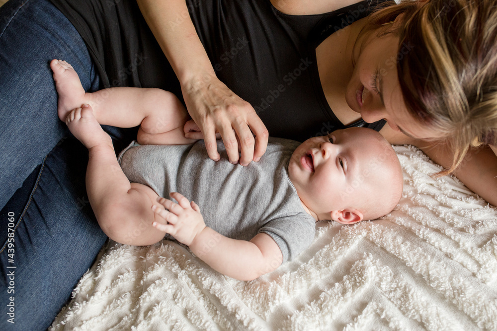 Mother curls around baby on bed Mother curls around baby on bed
