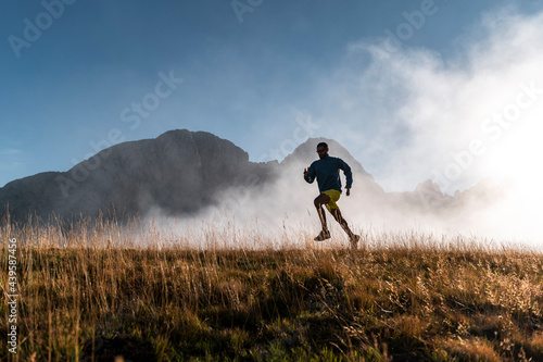 Silhouette of sportsman running against fog