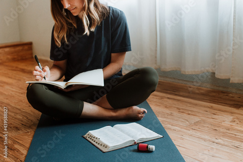 Woman in Background Journaling with Bible and Essential Oil in Foreground