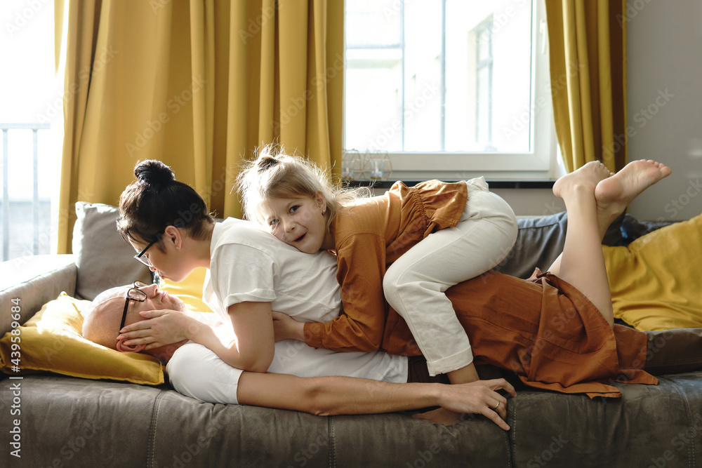 Happy family lying on the sofa and having fun at home Happy family lying on the sofa and having fun at home